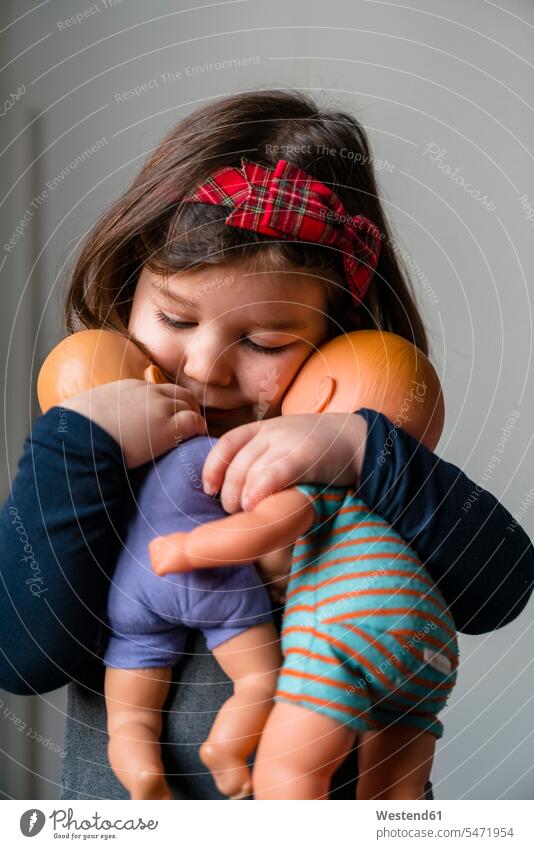Nahaufnahme eines süßen Mädchens, das seine Puppen zu Hause umarmt Farbaufnahme Farbe Farbfoto Farbphoto 2-3 Jahre 2 bis 3 Jahre 2 - 3 Jahre Kleinkinder
