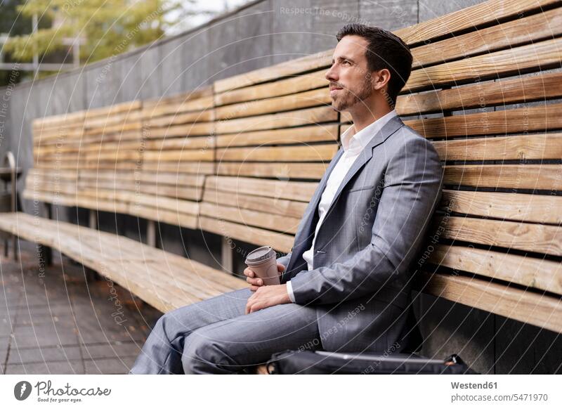 Entspannt Geschäftsmann sitzt auf Holzbank in der Stadt geschäftlich Geschäftsleben Geschäftswelt Geschäftsperson Geschäftspersonen Businessmann Businessmänner