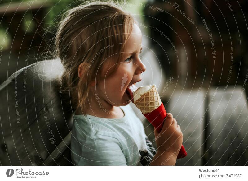 Mädchen isst Eiscreme sitzend auf Bank Bänke Sitzbank Sitzbänke essend kosten probieren sitzt sommerlich Sommerzeit geniessen Genuss erfrischen erfrischend Muße