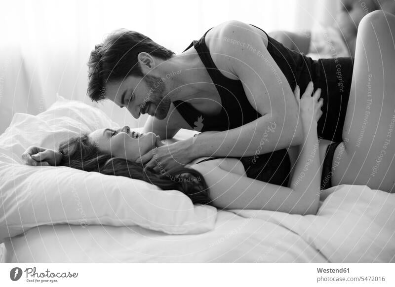 Erotisches Paar, das im Bett liegt und Liebe macht Lingerie Betten Arm umlegen Umarmung Umarmungen leidenschaftlich Leidenschaftlichkeit gefühlvoll Emotionen
