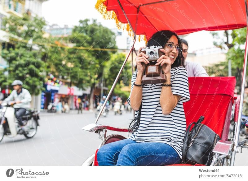 Vietnam, Hanoi, junge Frau mit altmodischer Kamera auf einer Rikscha Fotoapparat Fotokamera weiblich Frauen Rikschas fotografieren Erwachsener erwachsen Mensch