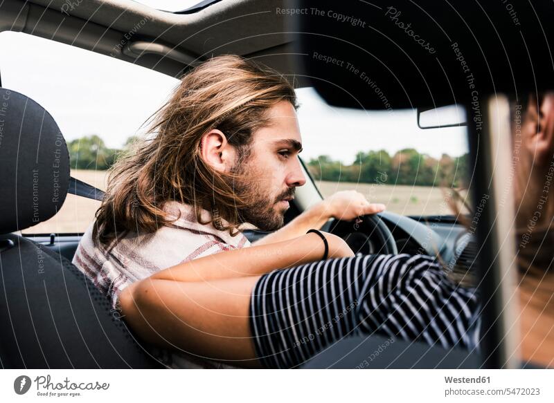 Junger Mann sieht Frau im Auto an Wagen PKWs Automobil Autos ansehen Paar Pärchen Paare Partnerschaft Kraftfahrzeug Verkehrsmittel KFZ schauen sehend Mensch