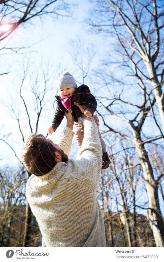 Vater hebt glückliche Tochter im Park hoch Glück glücklich sein glücklichsein hochheben Papas Väter Vati Vatis Papis Töchter Parkanlagen Parks Eltern Familie