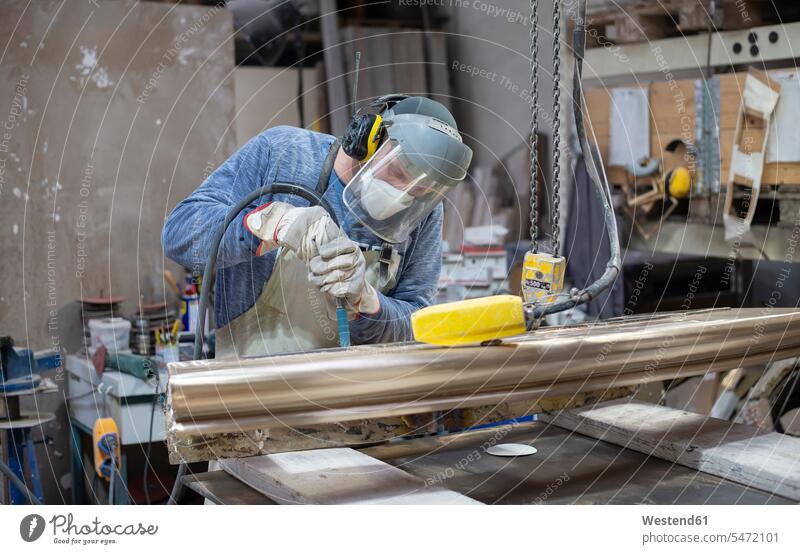Kunstgießerei, Gießereiarbeiter poliert Metall polieren schleifen Arbeiter Handwerker anfertigen Arbeitskleidung Arbeitsbekleidung Anfertigung Werkzeug