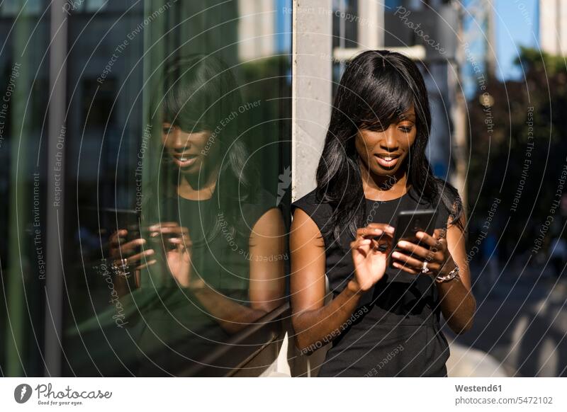 Geschäftsfrau mit Smartphone in der Stadt Leute Menschen People Person Personen Afrikanisch Afrikanische Abstammung dunkelhäutig Farbige Farbiger Schwarze