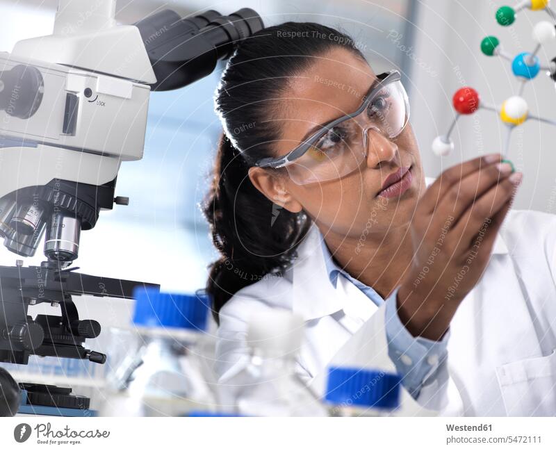 Biotechnology Research, Wissenschaftlerin, die eine chemische Formel mit Hilfe eines molekularen Kugel-Stock-Modells im Labor untersucht Forscher Analyse