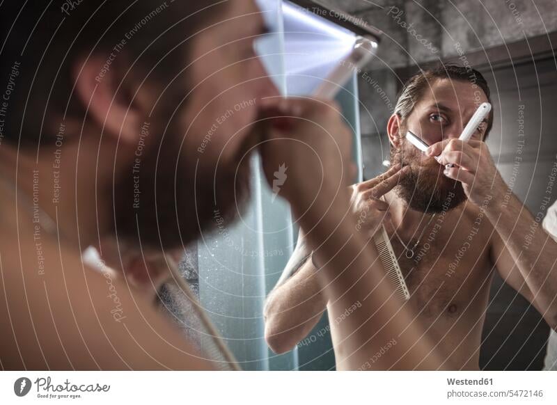 Porträt eines bärtigen Mannes, der beim Rasieren auf sein Spiegelbild schaut Männer männlich rasieren Rasur ansehen Spiegelbilder Erwachsener erwachsen Mensch