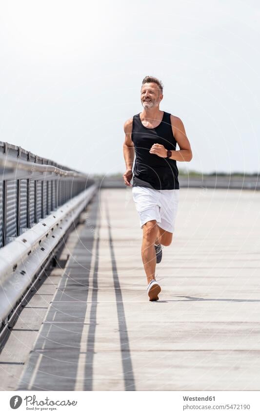 Sportlicher Mann beim Joggen rennen freuen Glück glücklich sein glücklichsein zufrieden Muße fit gesund Gesundheit Jogging Leistungen Dynamik dynamisch Power