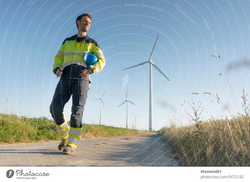 Ingenieur auf einem Feldweg in einem Windpark gehen gehend geht Ingenieure Windenergieanlage WEA WEAs Windkraftwerk Windenergieanlagen Windkraftwerke