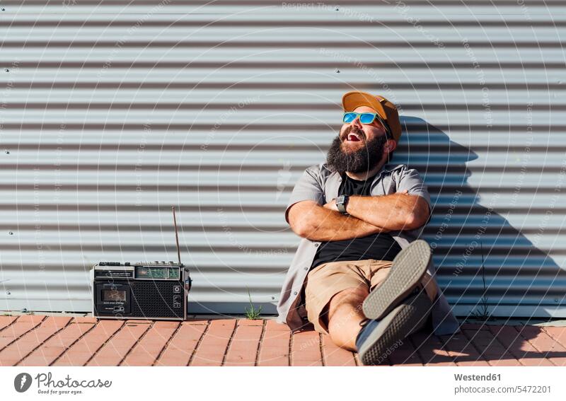 Porträt eines bärtigen Mannes mit tragbarem Radio im Sonnenlicht Leute Menschen People Person Personen Europäisch Kaukasier kaukasisch 1 Ein ein Mensch