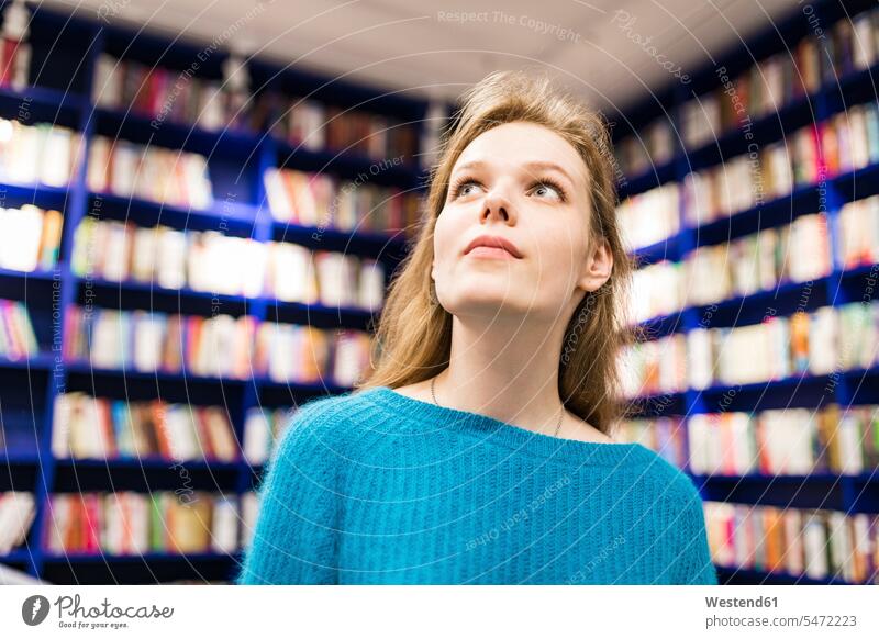 Porträt eines jugendlichen Mädchens in einer öffentlichen Bibliothek auf der Suche nach einem Buch Bücher Bücherei Portrait Porträts Portraits Teenagerin