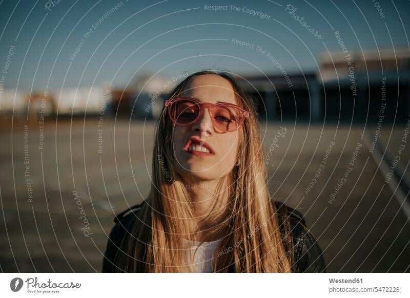 Porträt einer jungen Frau mit trotziger Haltung und Sonnenbrille im Freien Sonnenbrillen Brille Portrait Porträts Portraits Trotz weiblich Frauen innere Haltung