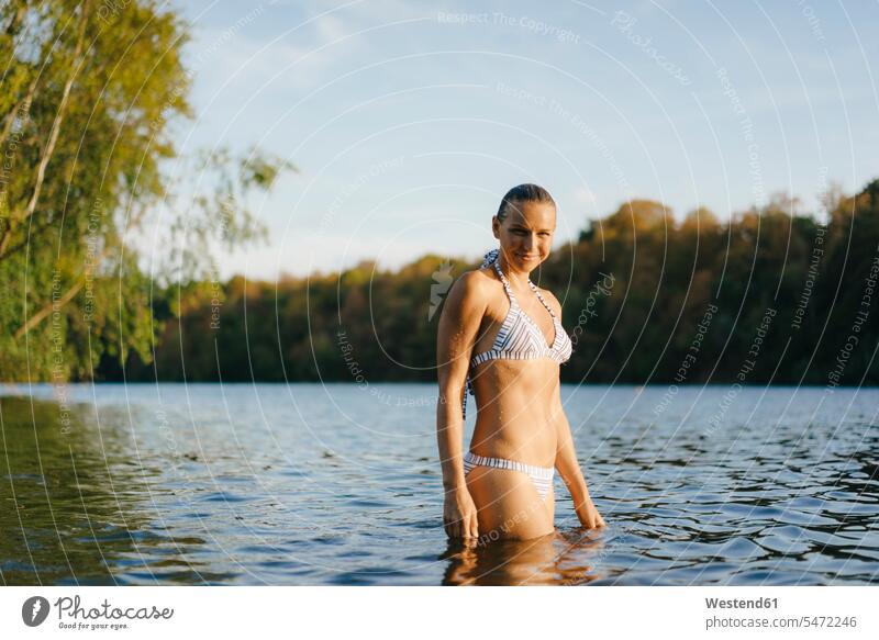 Porträt einer lächelnden Frau, die einen Bikini in einem See trägt Bikinis Portrait Porträts Portraits Seen weiblich Frauen Badekleidung Badebekleidung Gewässer