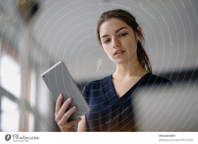 Porträt einer jungen Geschäftsfrau mit digitalem Tablett im Büro Leute Menschen People Person Personen Europäisch Kaukasier kaukasisch 1 Ein ein Mensch