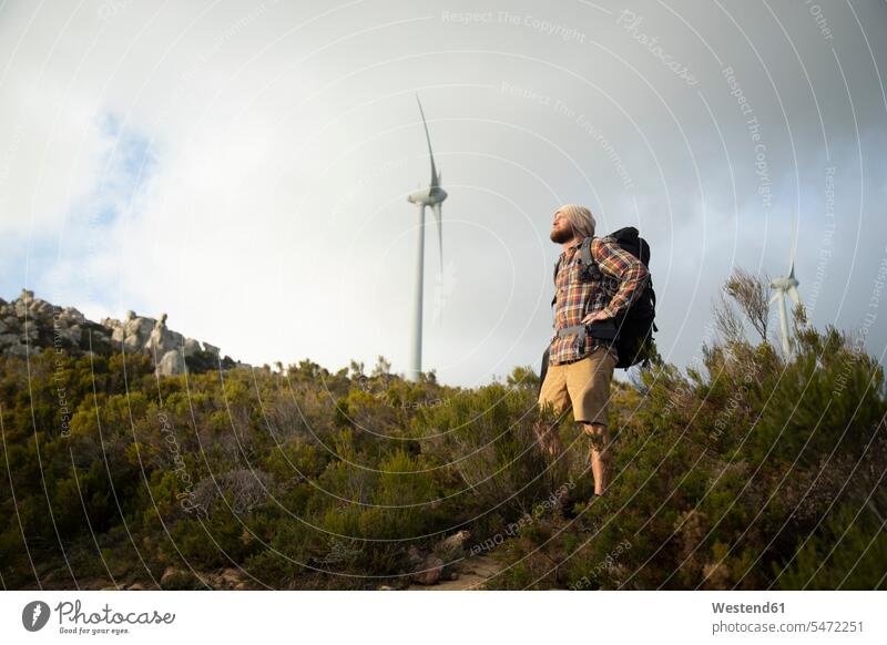 Spanien, Andalusien, Tarifa, Mann auf einer Wanderung mit Windrad im Hintergrund wandern stehen stehend steht Windturbine Windräder Wanderer Wandertour Männer