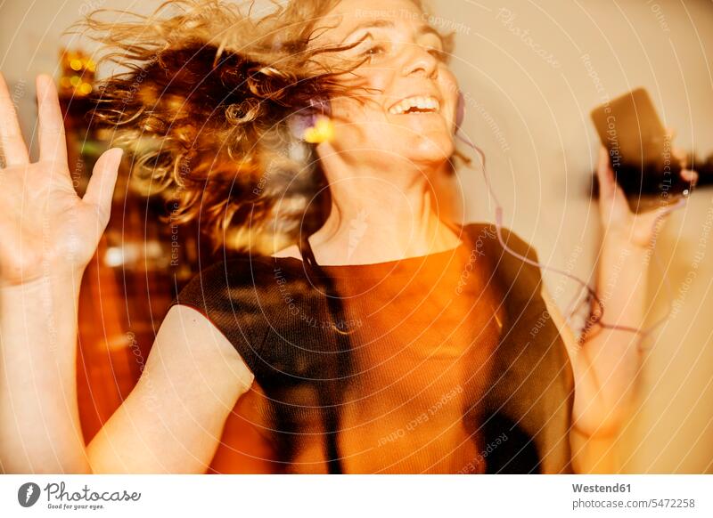 Nahaufnahme einer fröhlichen Frau, die tanzt, während sie zu Hause Musik hört Farbaufnahme Farbe Farbfoto Farbphoto Deutschland Freizeitbeschäftigung Muße Zeit