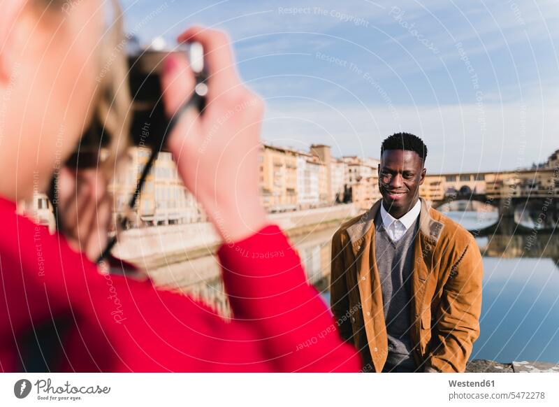 Junge Frau beim Fotografieren ihres Freundes auf einer Brücke über den Arno, Florenz, Italien Leute Menschen People Person Personen Afrikanisch