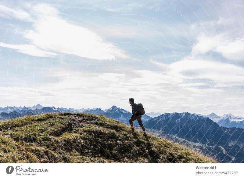 Österreich, Tirol, junger Mann wandert in den Bergen Gebirge Berglandschaft Gebirgslandschaft Gebirgskette Gebirgszug Männer männlich wandern Wanderung