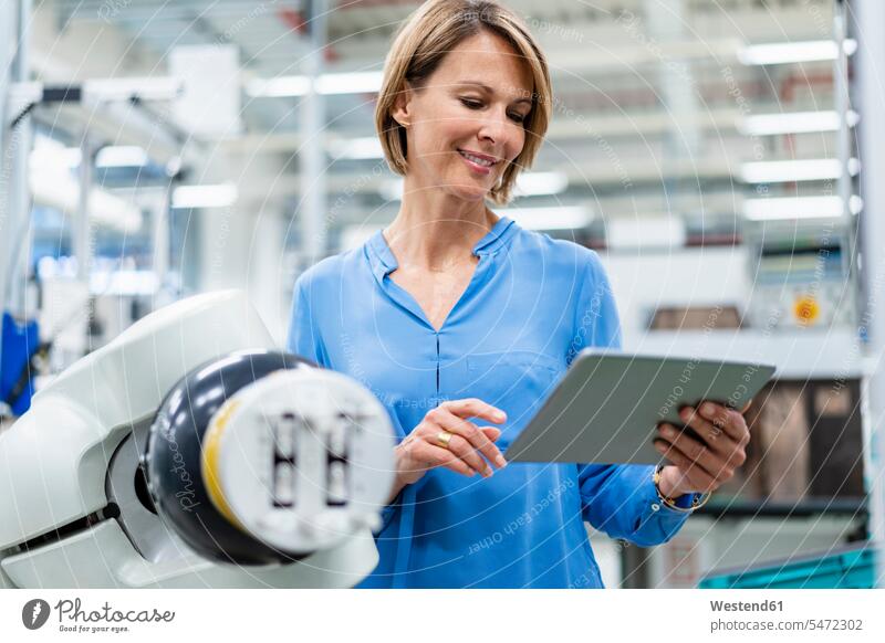 Geschäftsfrau mit Tablet am Montageroboter in einer Fabrik Leute Menschen People Person Personen Europäisch Kaukasier kaukasisch 1 Ein ein Mensch