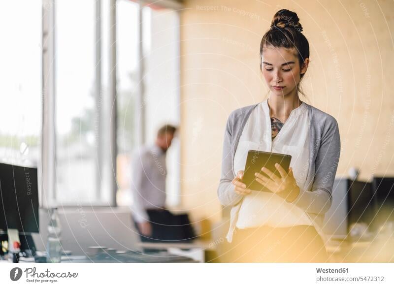Junge Frau arbeitet im Büro, mit Tablet Kollegen Arbeitskollegen Tablet Computer Tablet-PC Tablet PC iPad Tablet-Computer Geschäftsleute Geschäftspersonen