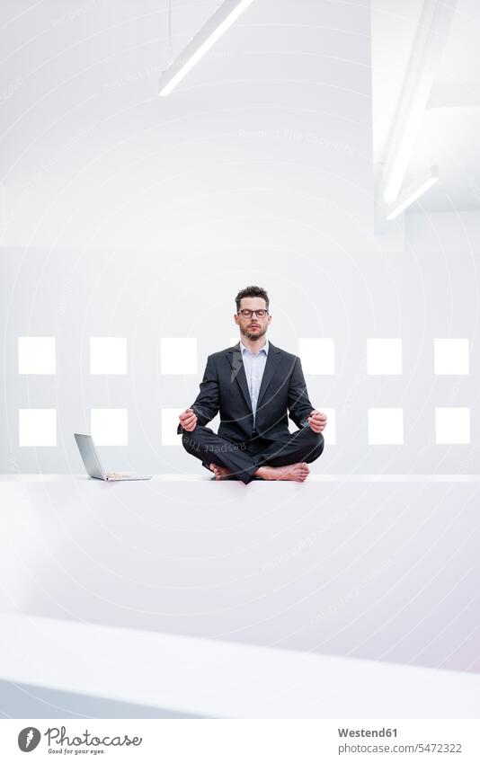Geschäftsmann macht Yoga im Büro neben dem Laptop Job Berufe Berufstätigkeit Beschäftigung Jobs geschäftlich Geschäftsleben Geschäftswelt Geschäftsperson