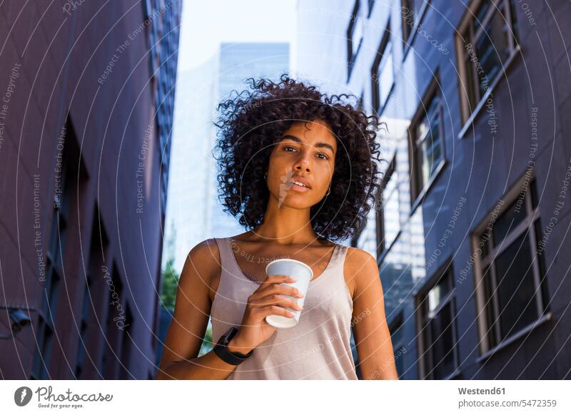 Deutschland, Frankfurt, Porträt einer jungen Frau mit Kaffee zum Mitnehmen in der Stadt Portrait Porträts Portraits staedtisch städtisch weiblich Frauen Getränk