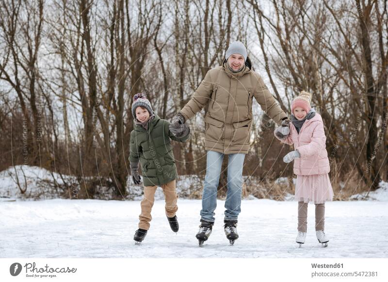 Zwei glückliche Geschwister laufen gemeinsam mit dem Vater auf dem Eis Leute Menschen People Person Personen Europäisch Kaukasier kaukasisch Gruppe von Menschen