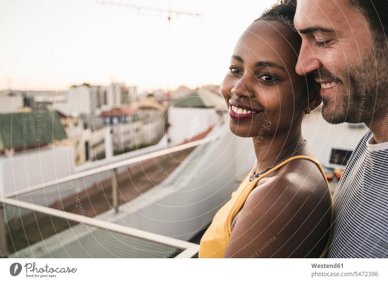 Porträt eines zärtlichen jungen Paares auf dem Dach am Abend Leute Menschen People Person Personen Afrikanisch Afrikanische Abstammung dunkelhäutig Farbige