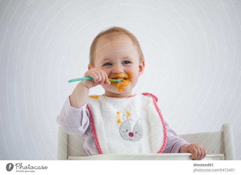 Porträt von verschmierten Baby Mädchen auf Hochstuhl Essen Brei Babies Babys Säuglinge Kind Kinder essen essend weibliche Babys weibliches Baby weibliche Babies