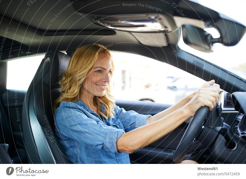 Lächelnde Frau fährt Auto weiblich Frauen Wagen PKWs Automobil Autos fahren fahrend fahrender fahrendes lächeln Erwachsener erwachsen Mensch Menschen Leute