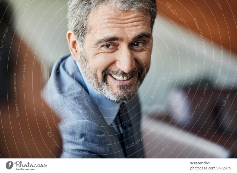 Porträt eines lächelnden Geschäftsmannes, der einen Kollegen anschaut Leute Menschen People Person Personen Europäisch Kaukasier kaukasisch Asiaten Asiatisch