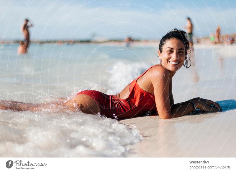 Lächelnde, mittelgroße, erwachsene Frau in Dessous, die am Strand gegen den Himmel liegt Farbaufnahme Farbe Farbfoto Farbphoto Spanien Freizeitbeschäftigung