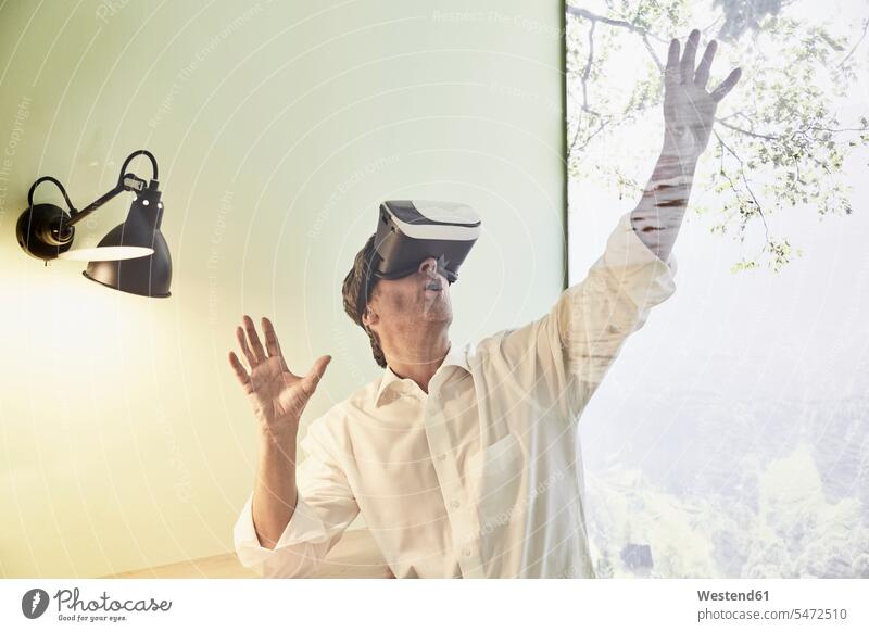Aufgeregter Geschäftsmann mit VR-Brille Brillen Businessmann Businessmänner Geschäftsmänner ansehen Virtuelle Realität Virtuelle Realitaet Geschäftsleute