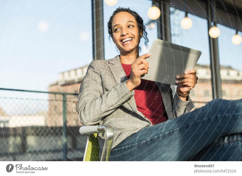 Glückliche junge Geschäftsfrau benutzt ein Tablett am Fenster im Büro Job Berufe Berufstätigkeit Beschäftigung Jobs Leute Menschen People Person Personen
