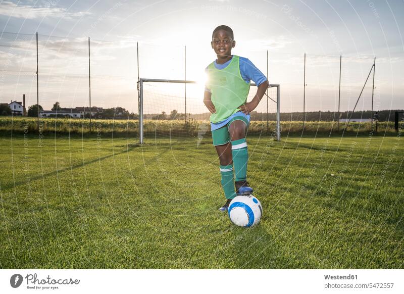Porträt eines selbstbewussten jungen Fussballspielers mit Ball auf dem Fussballplatz Fußballspieler Fussballer Fußballer Junge Buben Knabe Jungen Knaben
