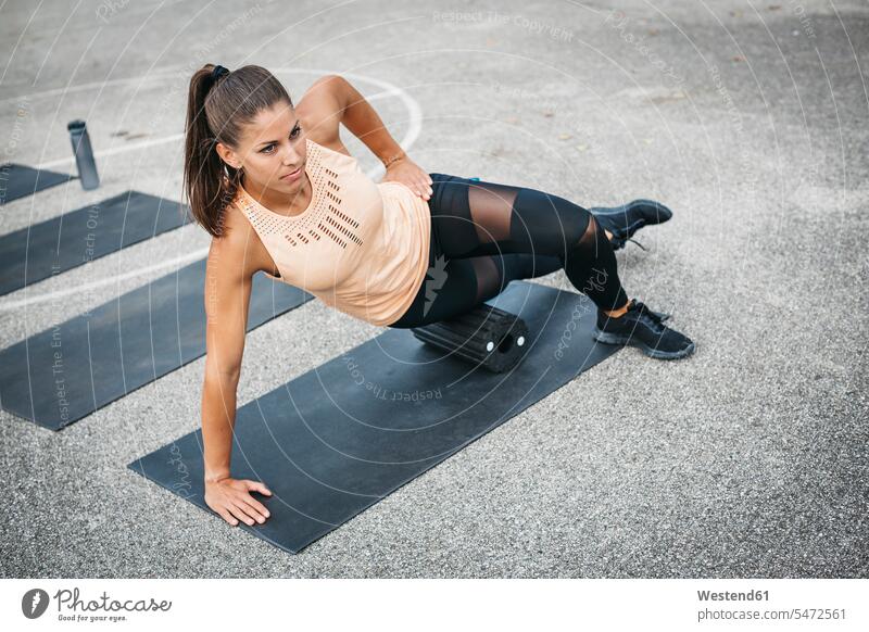 Junge Frau macht Seite Planke Übung mit Faszienrolle im Freien trainieren Side-Plank Seitenstütz Seitenstützen Faszienrollen weiblich Frauen Uebung Übungen