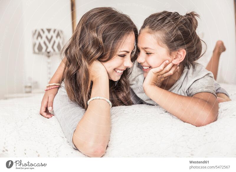 Glückliche Mutter und Tochter liegen zusammen im Bett und haben Spaß Leute Menschen People Person Personen Europäisch Kaukasier kaukasisch 2 2 Menschen
