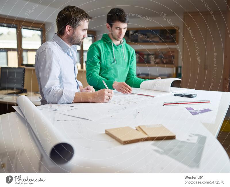 Architekten, die an Konstruktionszeichnungen arbeiten Zusammenarbeit Kooperation zusammenarbeiten zusammen arbeiten Teamwork Strategie Strategisch Bauzeichnung