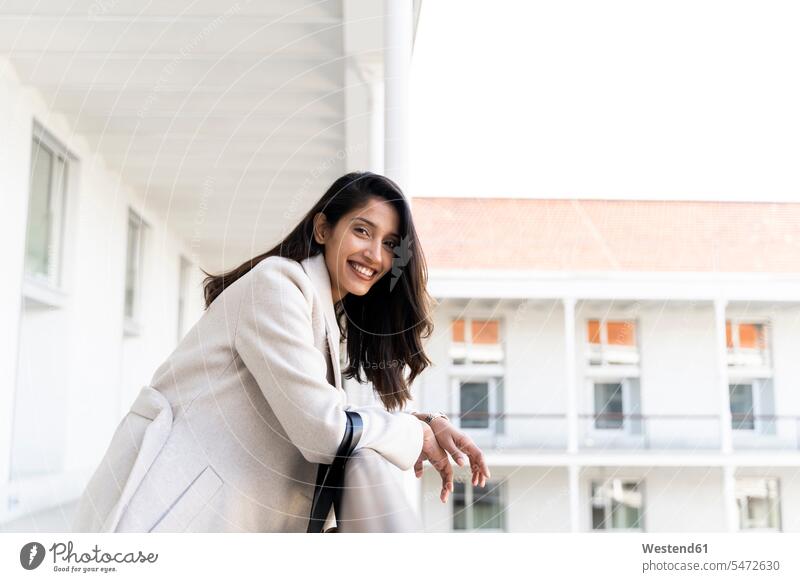 Porträt einer glücklichen jungen Frau auf dem Balkon Taschen Handtaschen entspannen relaxen entspanntheit relaxt freuen Frohsinn Fröhlichkeit Heiterkeit Glück