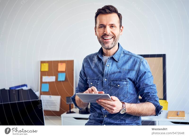 Porträt eines lächelnden Mannes mit Tablett im Büro Männer männlich Tablet Computer Tablet-PC Tablet PC iPad Tablet-Computer Office Büros Erwachsener erwachsen