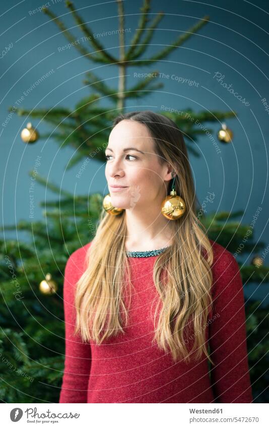 Porträt einer Frau mit goldenen Weihnachtskugeln und Ohrringen goldfarben goldfarbene Christbaumkugel Christbaumkugeln weiblich Frauen Portrait Porträts