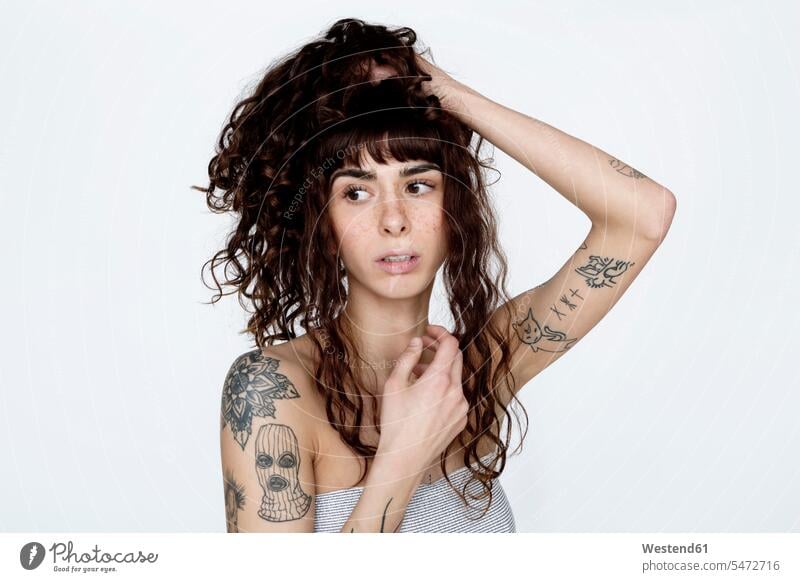 Porträt einer tätowierten jungen Frau mit Hand im Haar Haare Sommersprossen weiblich Frauen Tattoo Tätowierungen Tatoos Taetowierung Tattoos Taetowierungen