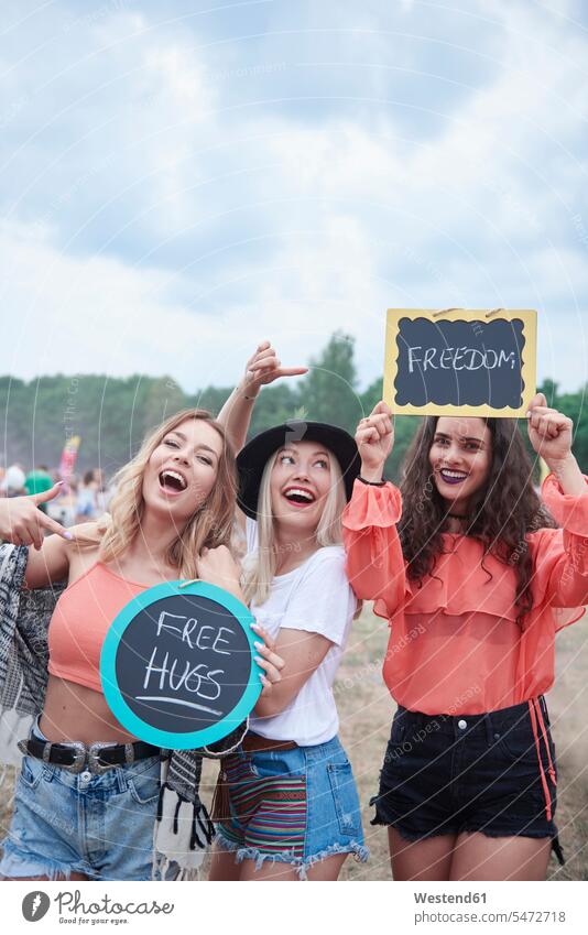 Glückliche Frauen beim Musikfestival mit Schildern, freien Umarmungen, Freiheit Freundinnen glücklich glücklich sein glücklichsein free hugs Musiktage