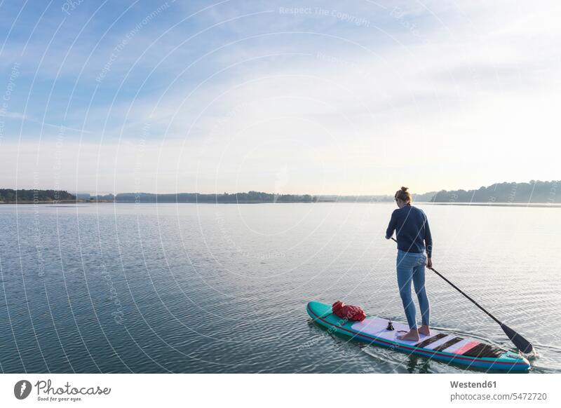 Frau steht morgens auf einem See an Bord früh Frühe Morgen Jahreszeiten sommerlich Sommerzeit stehend Muße ausgeglichen Ausgeglichenheit Gleichgewicht auf Achse