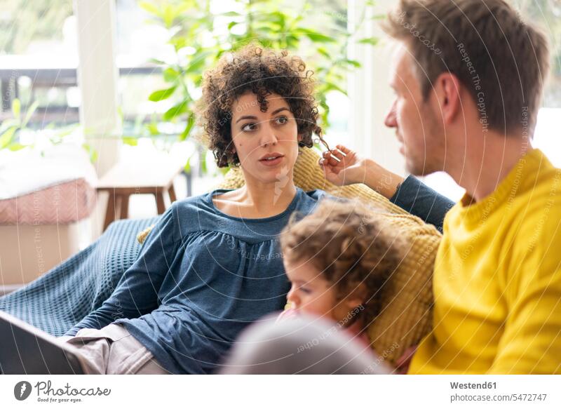Familie liegt auf der Couch und schaut einen Film auf ihrem Tablet Sofa Couches Liege Sofas fernsehen Familien Mutter Mami Mutti Mütter Mama Vater Papas Väter