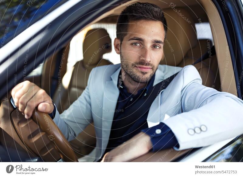 Erfolgreicher junger Geschäftsmann fährt in seinem Auto Businessmann Businessmänner Geschäftsmänner Wagen PKWs Automobil Autos unterwegs auf Achse in Bewegung