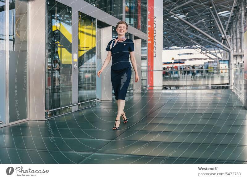 Porträt von lächelnden Airline-Mitarbeiter zu Fuß auf dem Flughafen Stewardess Stewardessen Flugbegleiterinnen Frau weiblich Frauen Flughaefen Airport Airports