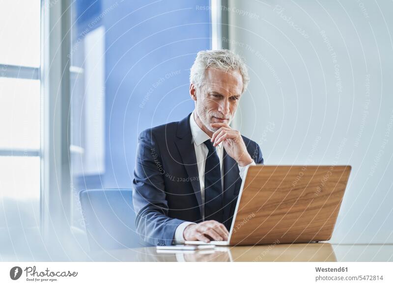 Fokussierter Geschäftsmann mit Laptop am Schreibtisch im Büro Job Berufe Berufstätigkeit Beschäftigung Jobs geschäftlich Geschäftsleben Geschäftswelt