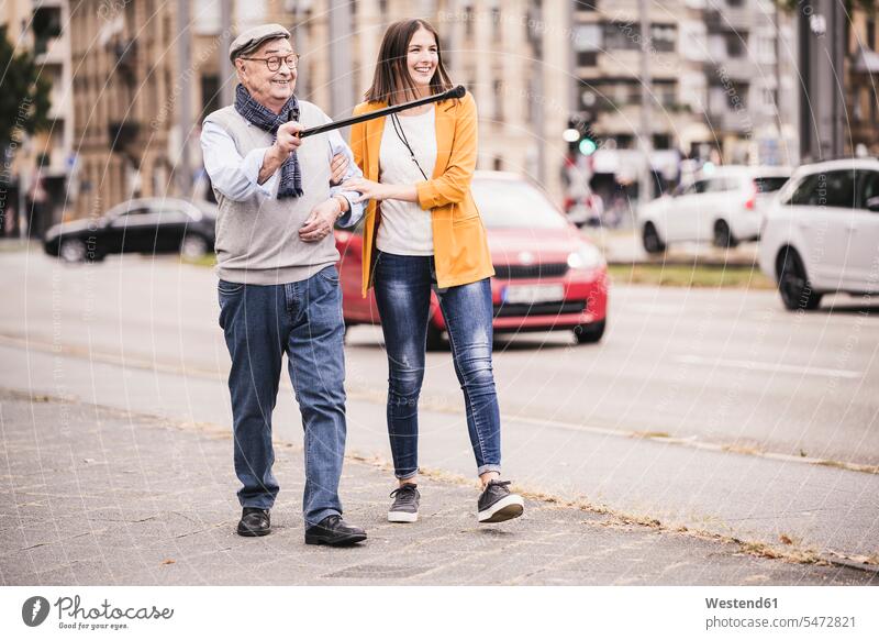 Erwachsene Enkelin, die ihrem Großvater beim Laufen hilft Leute Menschen People Person Personen Europäisch Kaukasier kaukasisch 2 2 Menschen 2 Personen zwei