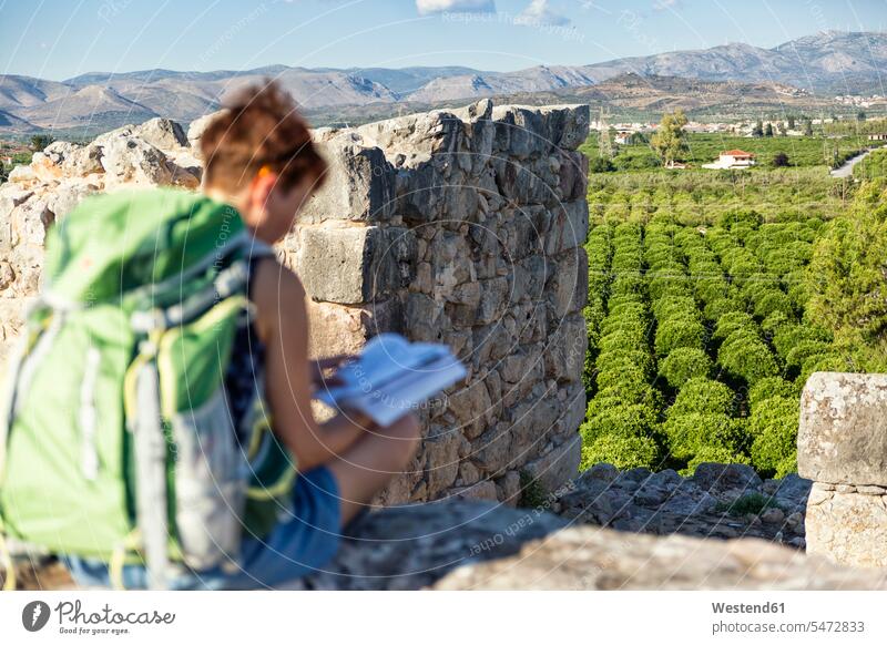 Griechenland, Peloponnes, Argolis, Tiryns, archäologische Stätte, Touristin liest Reiseführer Buch Bücher lesen Lektüre informieren Reisefuehrer Reisende